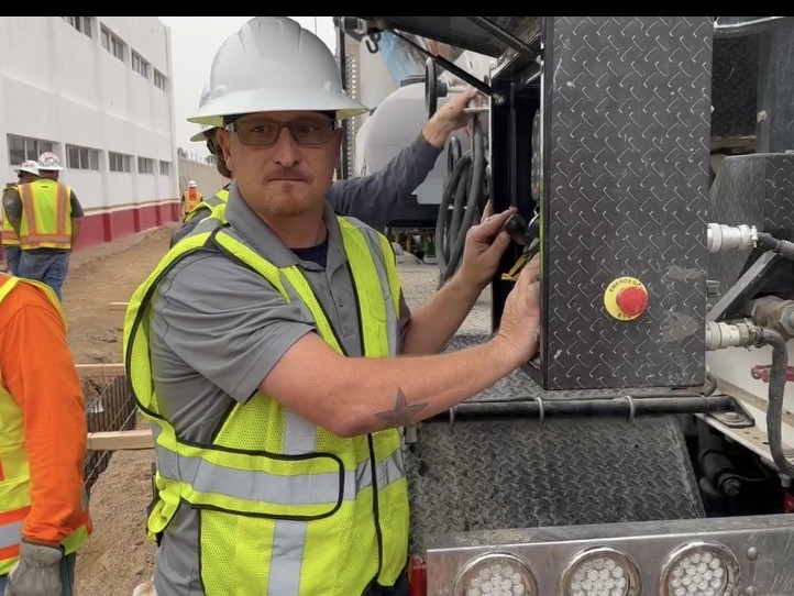 Zach Miller working on a jobsite beside mixer equipment
