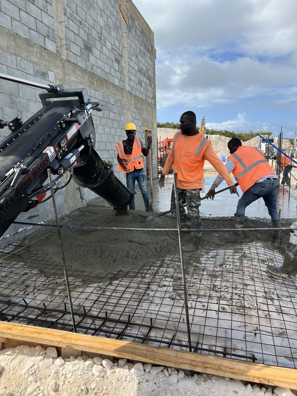 Crew placing concrete over reinforcing steel